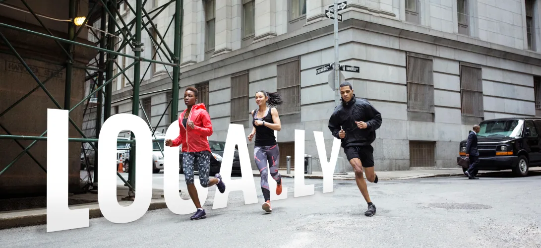 Three runners crossing a city street, with the Locally wordmark set into the scene.